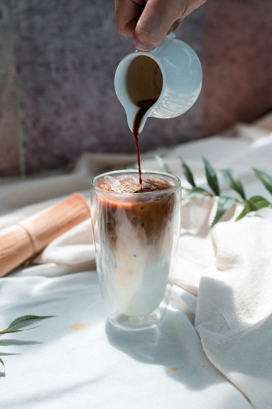 An iced chocolate drink on a summer table with condensation on the glass, styled like a cocktail.